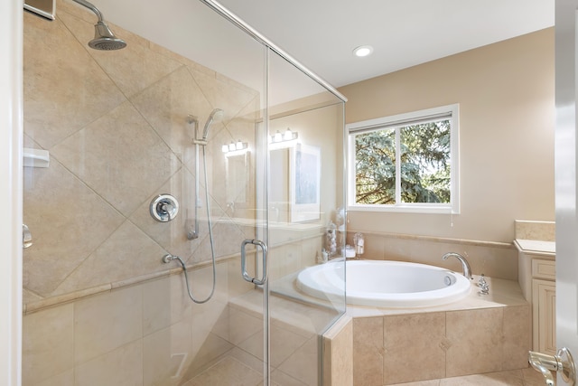 bathroom featuring vanity, a bath, and a shower stall