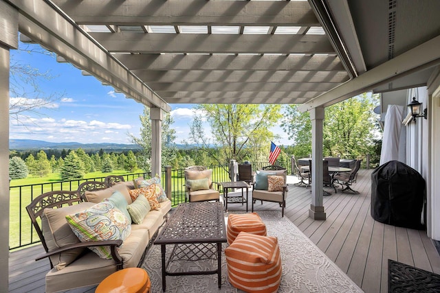 wooden deck with grilling area, outdoor dining area, a mountain view, an outdoor hangout area, and a pergola