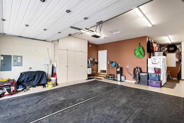 garage with a garage door opener and electric panel