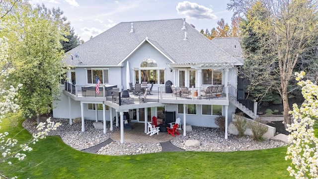 rear view of property featuring roof with shingles, a patio area, a yard, a pergola, and stucco siding