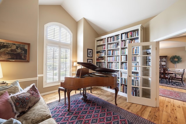 sitting room featuring high vaulted ceiling and wood finished floors