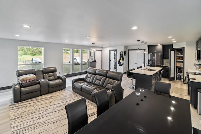 living room with light wood-style floors, baseboards, and recessed lighting