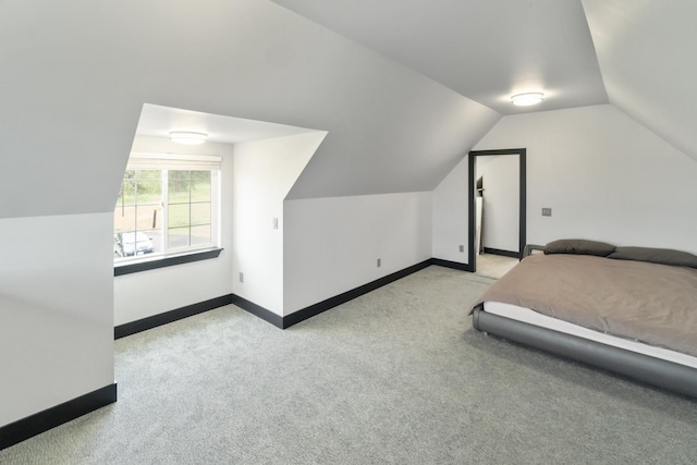 bedroom featuring carpet floors, baseboards, and lofted ceiling