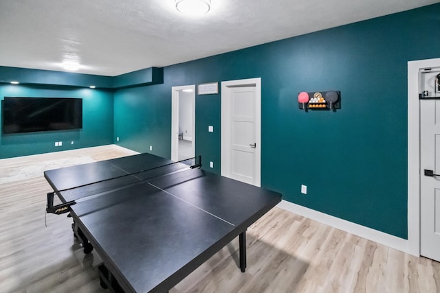 recreation room featuring baseboards and wood finished floors