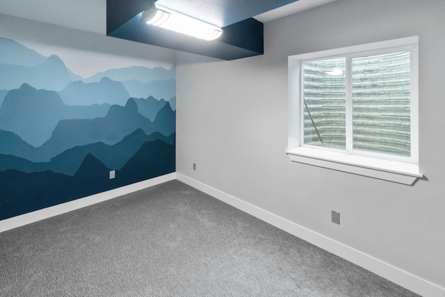 carpeted empty room featuring baseboards