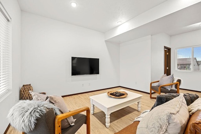 living area featuring recessed lighting, baseboards, and light wood-style floors