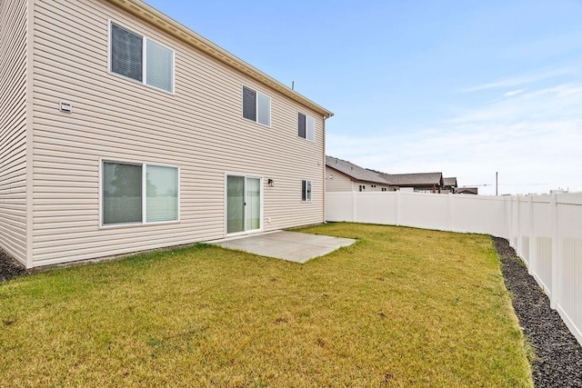 rear view of house with a lawn, a fenced backyard, and a patio area
