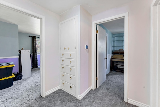 hallway with baseboards and carpet