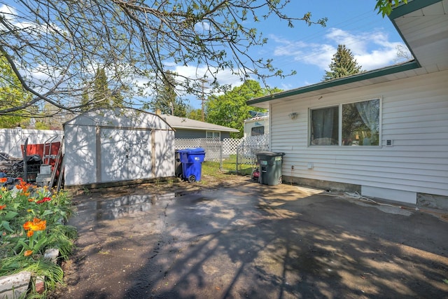 view of patio with fence, an outbuilding, and a shed