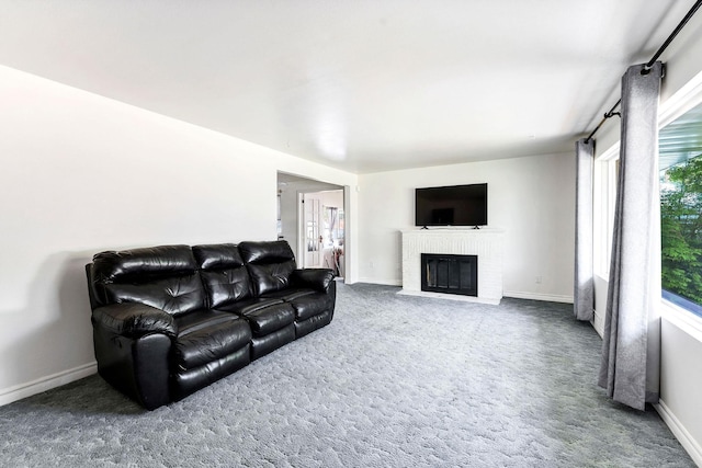 carpeted living area featuring a brick fireplace and baseboards