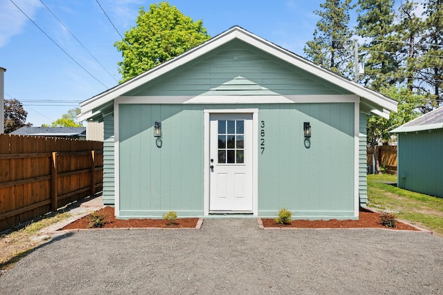 view of outbuilding featuring fence and an outdoor structure