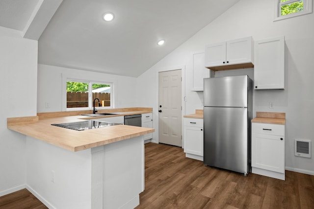 kitchen featuring a sink, appliances with stainless steel finishes, white cabinets, and butcher block countertops
