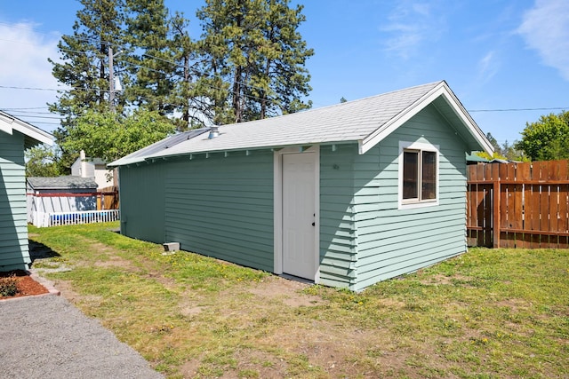view of outdoor structure featuring fence and an outbuilding