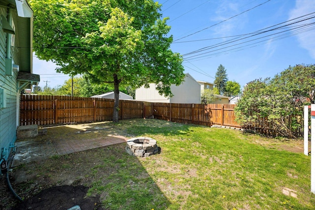 view of yard featuring a patio, a fire pit, and a fenced backyard