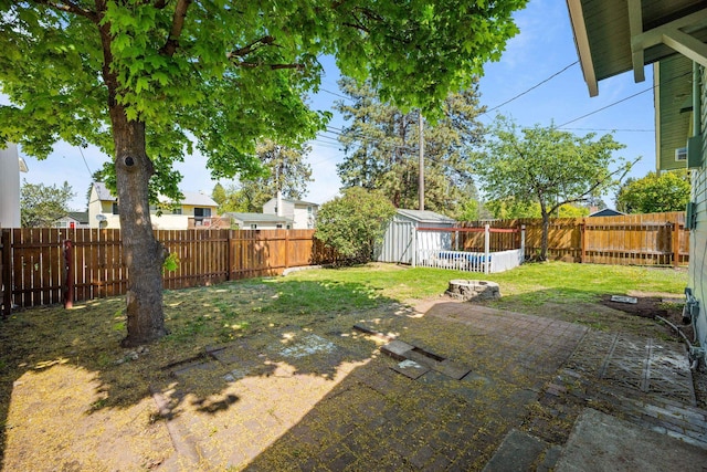 view of yard featuring a patio, an outbuilding, a fenced backyard, and a storage shed