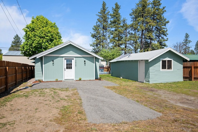 view of outbuilding with fence and an outbuilding