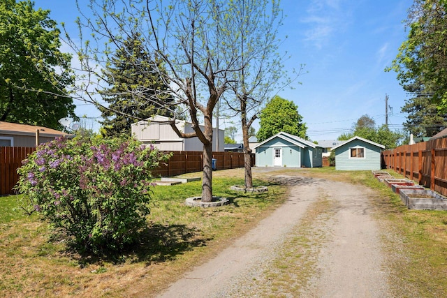 view of front of house featuring fence and dirt driveway