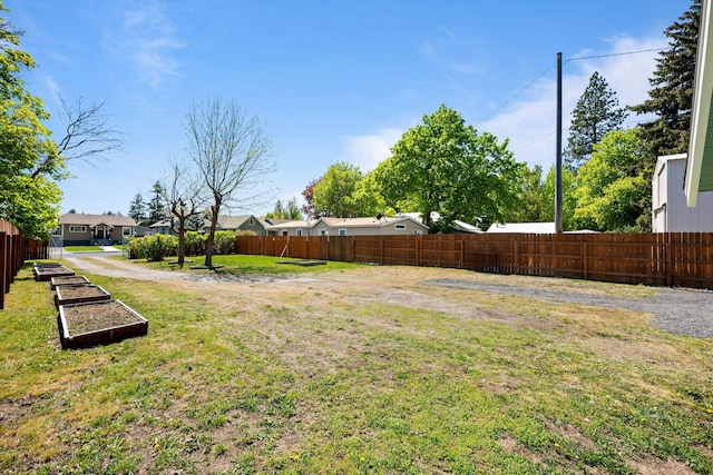view of yard with a residential view, fence, and a garden