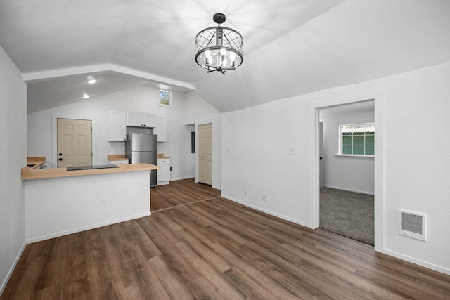 unfurnished living room featuring baseboards, visible vents, dark wood finished floors, and lofted ceiling