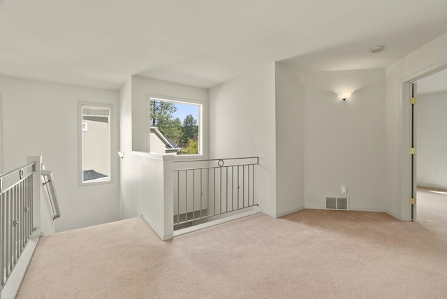 unfurnished room featuring baseboards, visible vents, and carpet