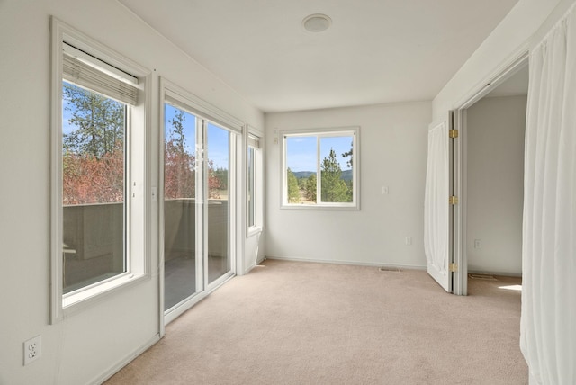 unfurnished sunroom featuring a healthy amount of sunlight and visible vents