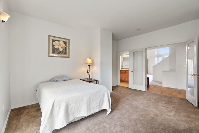 bedroom with baseboards, carpet, and ensuite bathroom