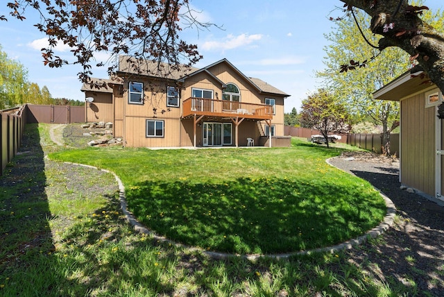 back of house with a lawn, a deck, and a fenced backyard
