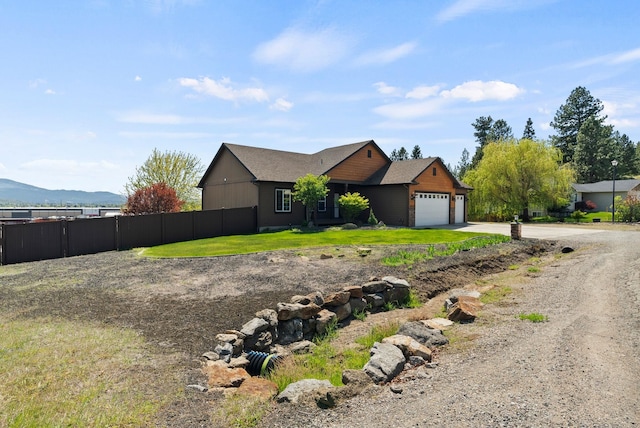 view of front of property featuring fence, a mountain view, an attached garage, and concrete driveway