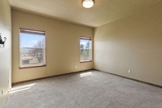 carpeted spare room with baseboards