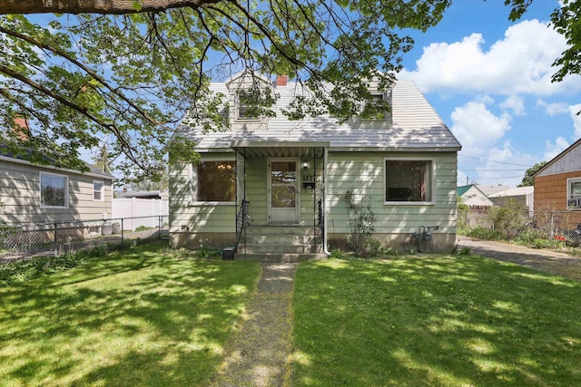 view of front facade with entry steps, fence, and a front lawn