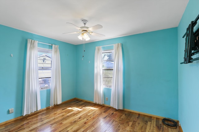 spare room featuring baseboards, ceiling fan, and hardwood / wood-style floors
