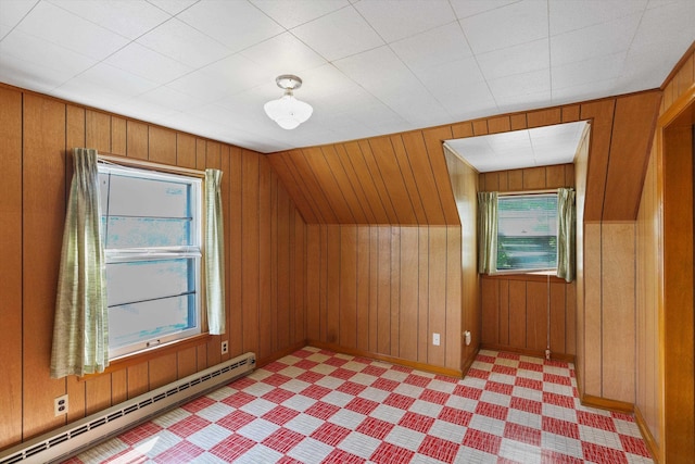 bonus room with a baseboard radiator and wooden walls