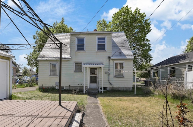 back of property featuring a chimney, a deck, fence, a yard, and entry steps