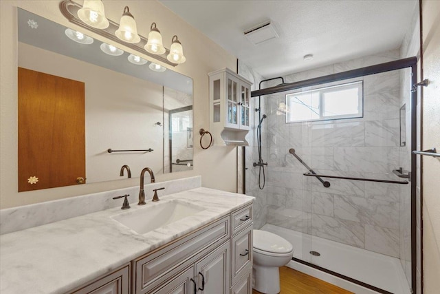 full bath featuring vanity, a shower stall, toilet, and wood finished floors
