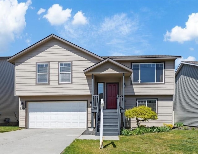 split foyer home with an attached garage, driveway, and a front lawn