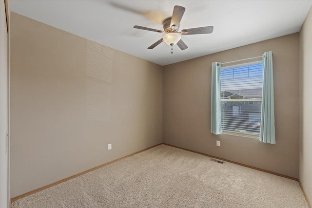 unfurnished room featuring carpet floors, baseboards, ceiling fan, and visible vents