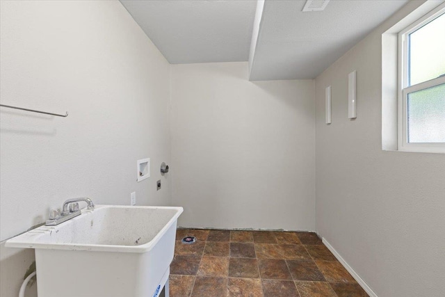 clothes washing area with laundry area, stone finish floor, a sink, and hookup for a washing machine