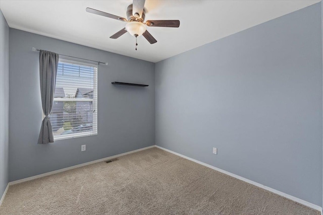 carpeted spare room with a ceiling fan, baseboards, and visible vents