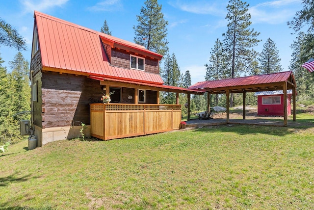 back of property featuring a lawn, metal roof, and a carport