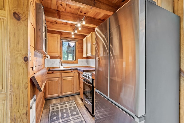 kitchen featuring beamed ceiling, wood ceiling, a sink, light wood-style flooring, and stainless steel appliances