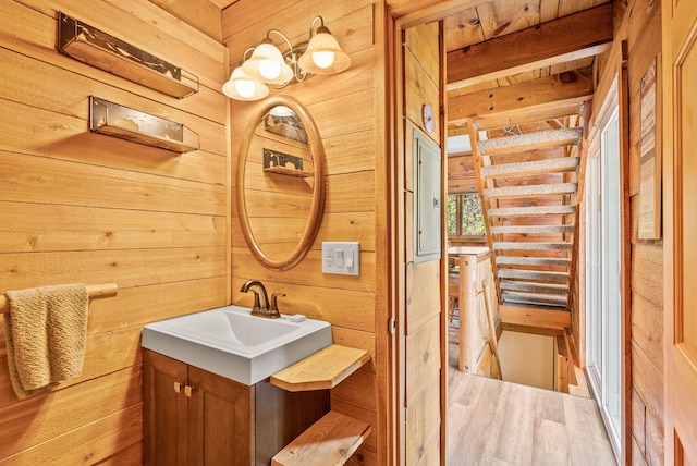bathroom featuring wooden walls, wood finished floors, and vanity