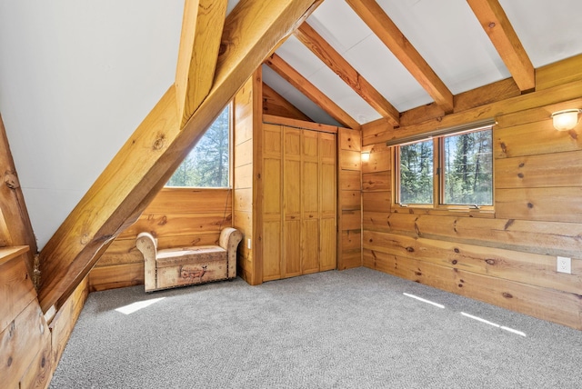 bonus room featuring lofted ceiling with beams, carpet flooring, and wood walls