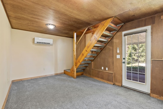 basement featuring stairway, wooden ceiling, carpet, and a wall mounted air conditioner