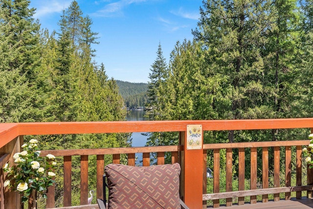 wooden terrace with a view of trees and a water view