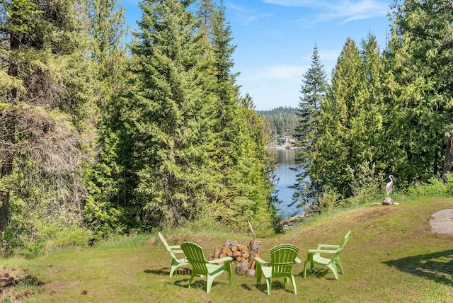 view of yard with a water view and a forest view