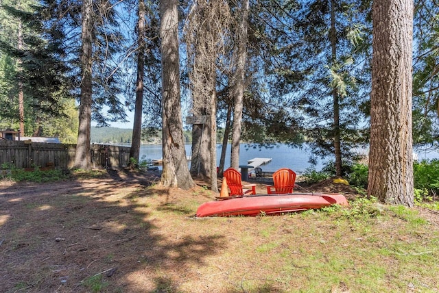 view of yard with a water view and fence