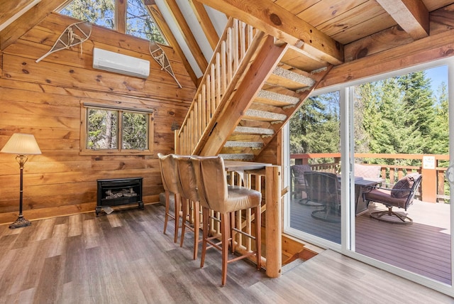 interior space with an AC wall unit, a wealth of natural light, and wood finished floors