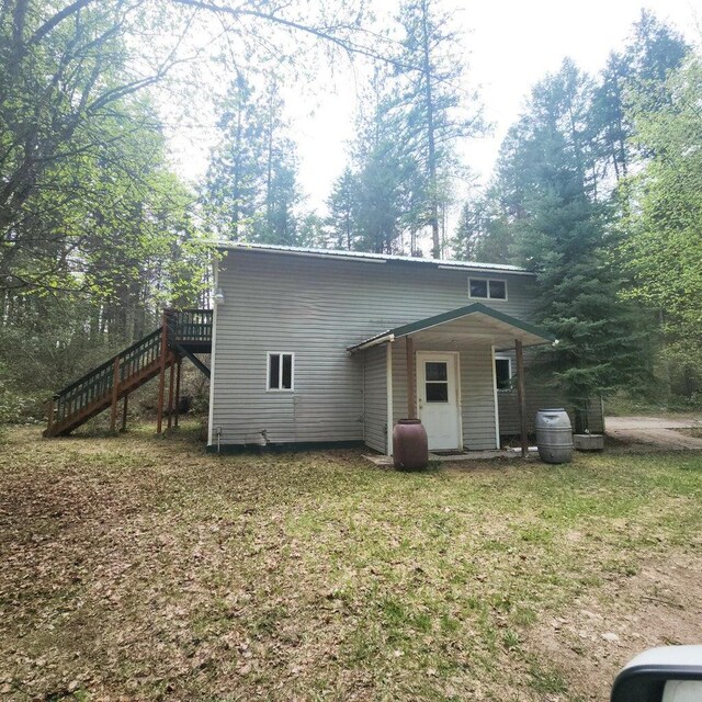 rear view of house featuring stairway and a deck