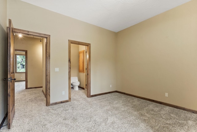 8605 E S Riverway Ave, Spokane, WA 99212 - unfurnished bedroom featuring baseboards, ensuite bath, and light colored carpet