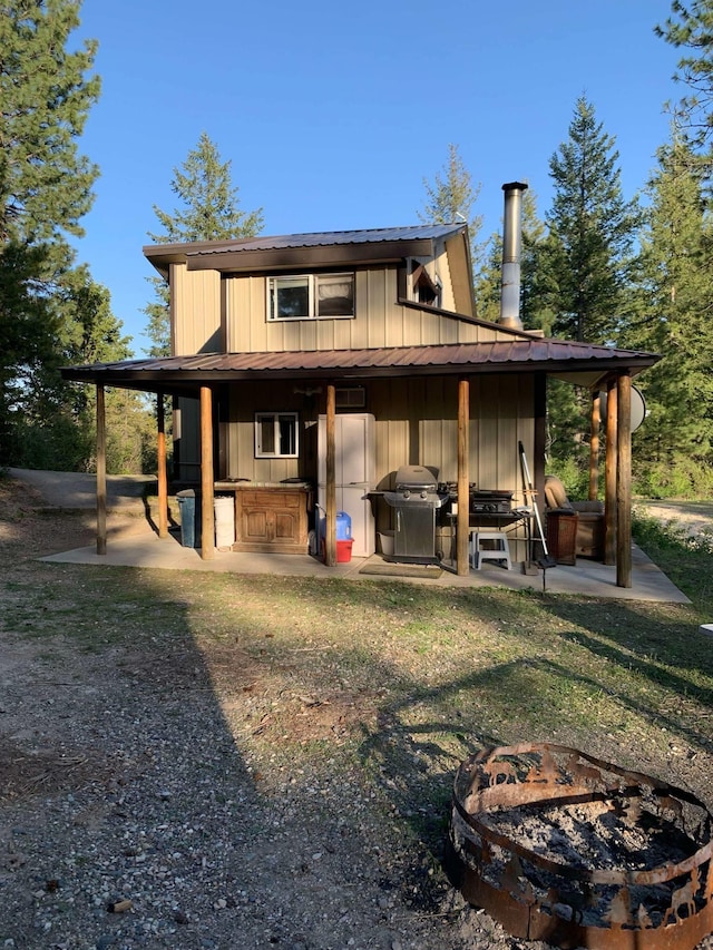 rear view of property with board and batten siding and a patio area